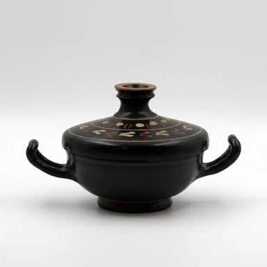 An ancient black glazed pottery vessel with two handles and a decorated lid, featuring gold cloud patterns.