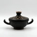 An ancient black glazed pottery vessel with two handles and a decorated lid, featuring gold cloud patterns.