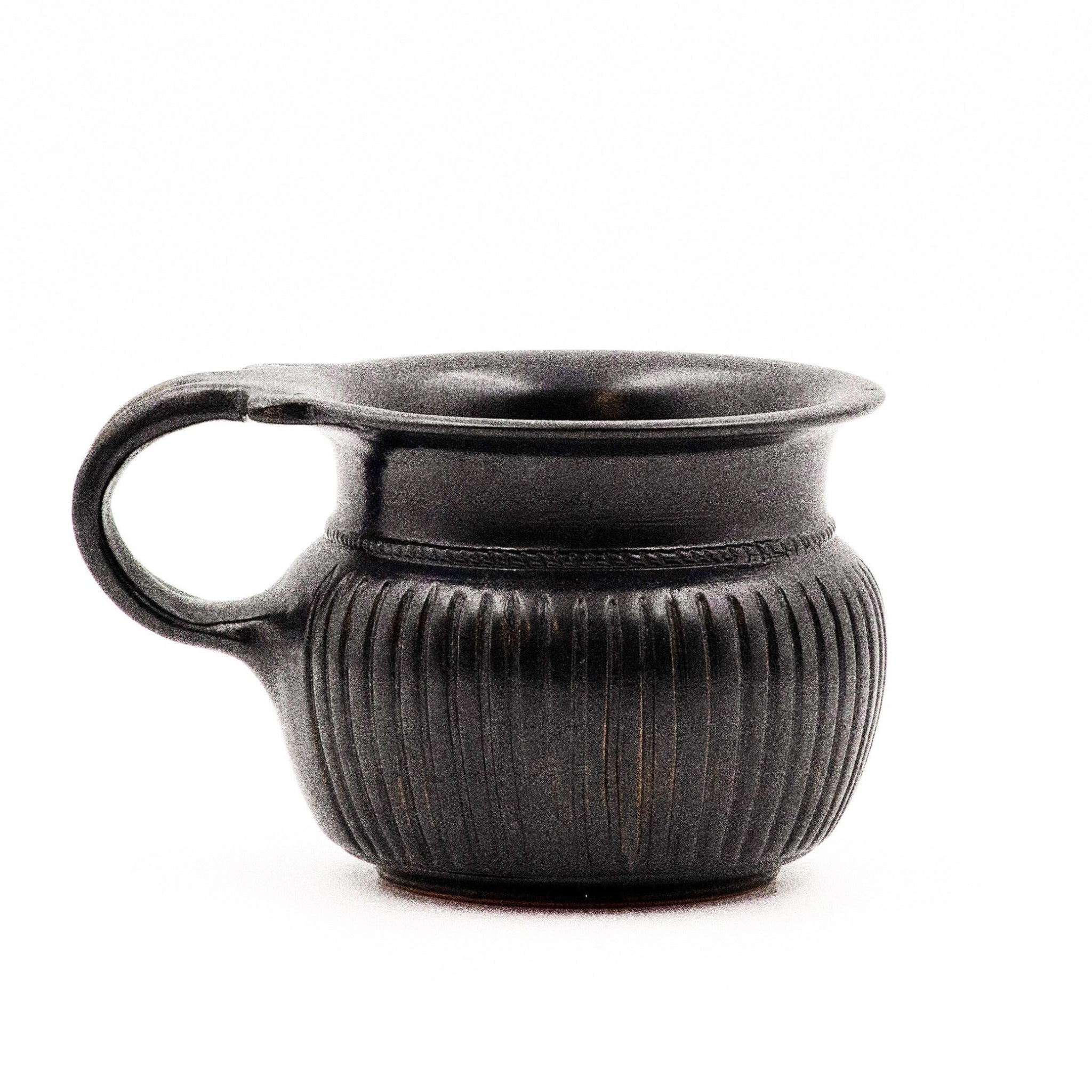 A black glazed ribbed mug with neat reeding and a double handle, reminiscent of ancient Greek pottery.