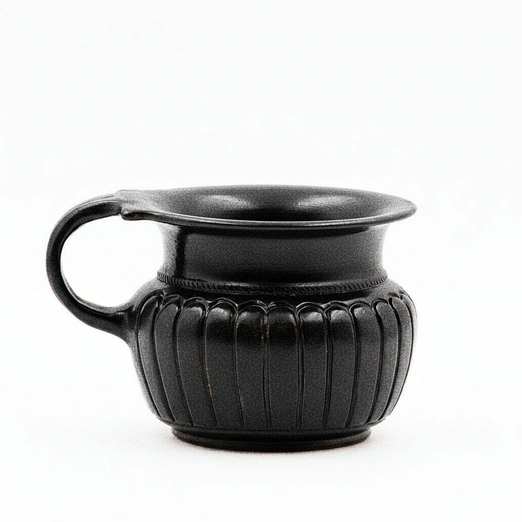 A black glazed ribbed ceramic mug with a double handle and rope-like incisions at the junction of the body and rim.