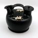 A black glazed ceramic askos with white painted decoration depicting horses. It has two spouts and a lid, resembling an ancient Greek pottery style.