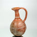 A Cypriot red polished ceramic flask with geometric patterns.