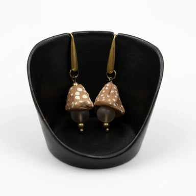 A pair of dot funnel bead and glass drop earrings displayed in a black setting, with gold-colored accents and drops.