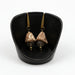 A pair of dot funnel bead and glass drop earrings displayed in a black setting, with gold-colored accents and drops.