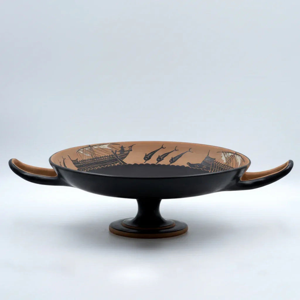 Handmade ancient Greek ceramic kylix with black-figure ship and dolphin design on pedestal