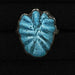 Blue ceramic leaf-shaped object on a black background