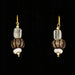 A pair of drop earrings featuring glazed beads and a glass drop design with gold accents on a black background.