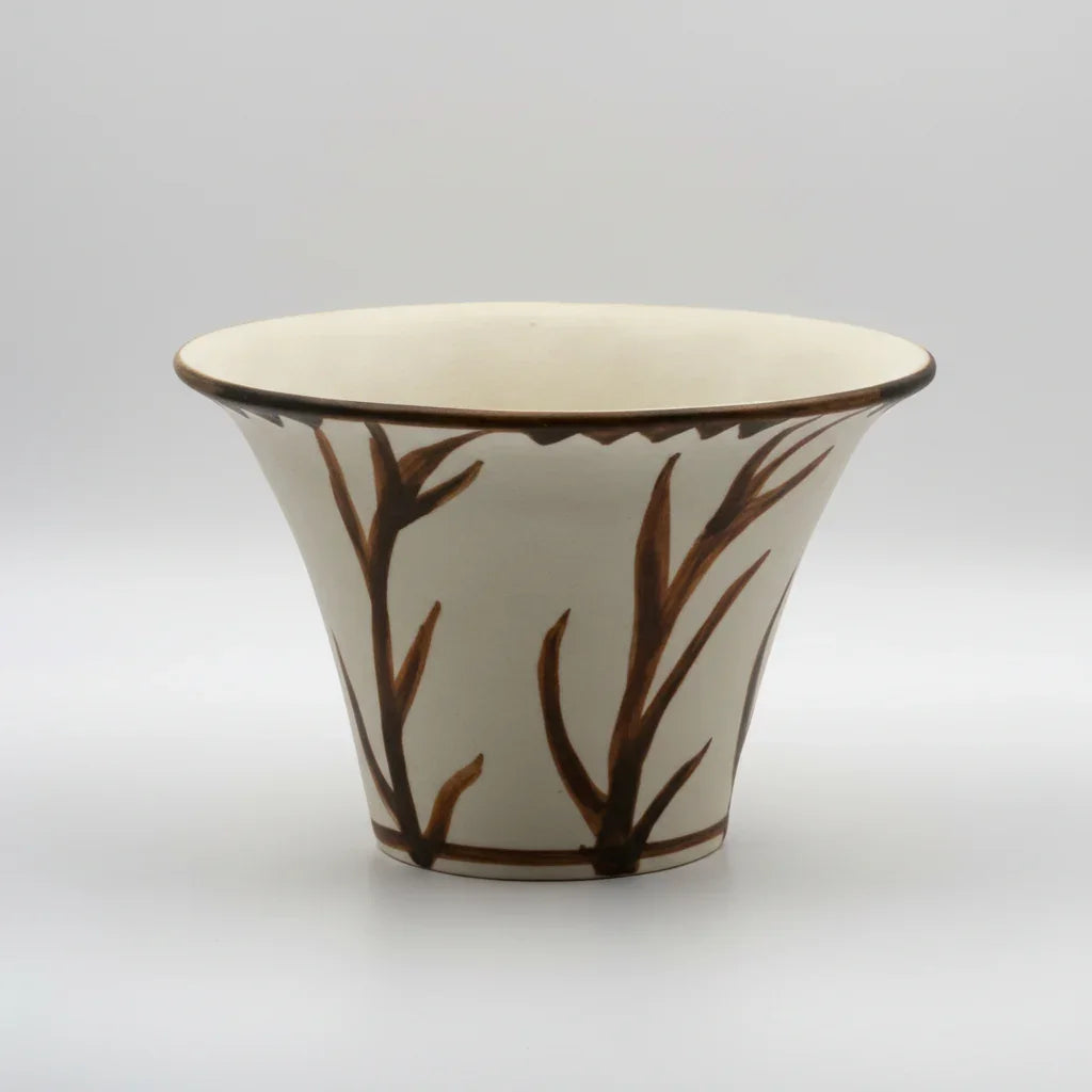 A small conical vase with a flaring lip and painted decoration of plant motives on a white background.