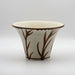 A small conical vase with a flaring lip and painted decoration of plant motives on a white background.