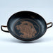 An ancient Greek style kylix with a depiction of a mythological scene in red on a black background.
