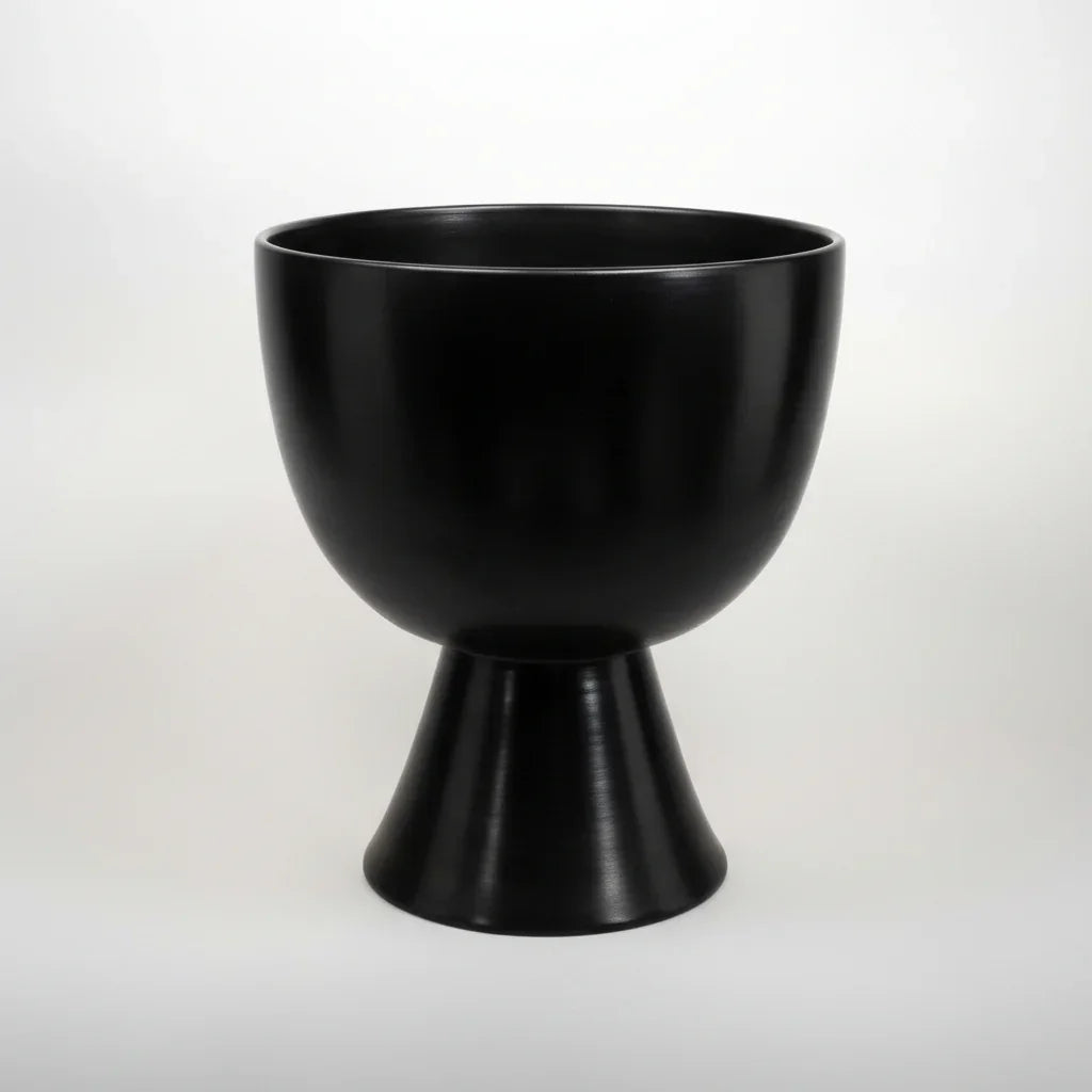 A black round pedestal bowl on a white background
