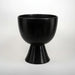 A black round pedestal bowl on a white background