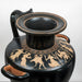 Black ceramic vase with gold decorative figures on a white background