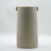 A hand-built cylindrical stoneware vase with a grayish-white color and attached knob-like handles near the rim.