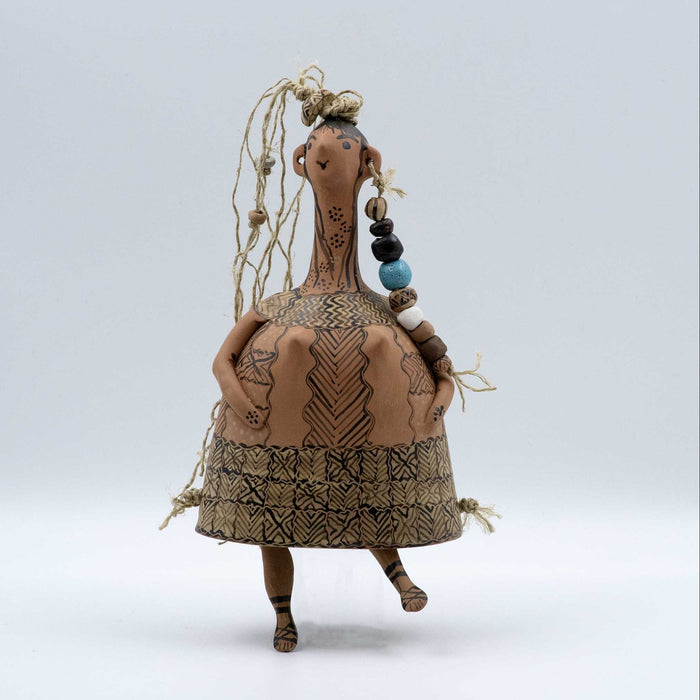 Textile art doll with patterns and beads on a light gray background