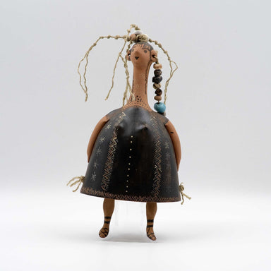 Ceramic art doll with black dress and braided hair on a white background